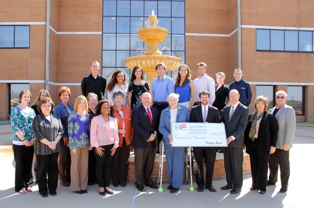 Peoples Bank of Magnolia, Ark., has made an investment of $25,000 in the College of Business at Southern Arkansas University. The contribution will fund $5,000 for current use of the College, with the remaining $20,000 endowing the Harold Fincher and Gerald F. Scott SIFE/ENACTUS Enrichment Endowment. This endowment will benefit business students who participate in state and national ENACTUS competitions. Pictured are (Left to Right) Back Row: ENACTUS students Ben Bower, Yalile Johnson, Megan Maye, Christian Hunter, Megan Godsel, Chase Hardy, Lacy Guy, and Andrew Sawyer. Second Row: Peoples Bank Representatives Leslie Sharp, Dina Hayes, Fonda Miller, Sharon Gathright, and Jill McClinton; SAU Vice President of Academic Affairs Dr. Trey Berry; D.J. Fincher; Jonathan Baird; SAU President Dr. David Rankin; Dean of the SAU College of Business Dr. Lisa Toms; and Dr. James Clark, SAU Associate Professor of Marketing and ENACTUS Advisor.